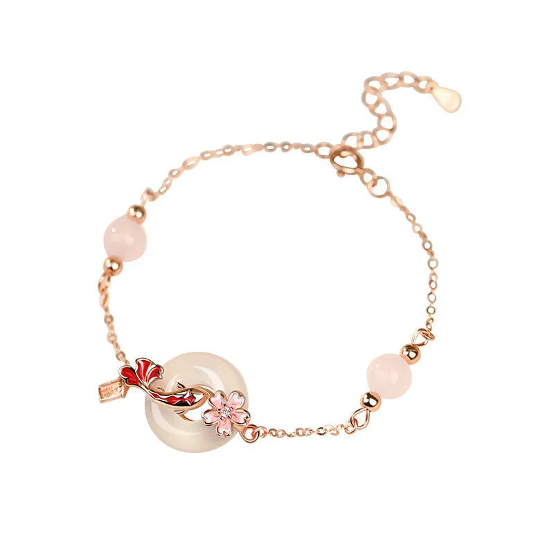 Close-up of a sterling silver bracelet with white chalcedony stones in a koi design on a wrist.