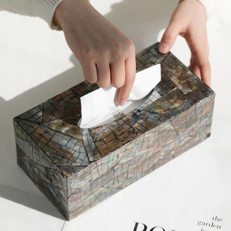 Black rectangular and square natural shell tissue box storage holder on a coffee table.