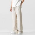Man wearing beige loose-fit straight-leg cropped trousers with a drawstring waist.