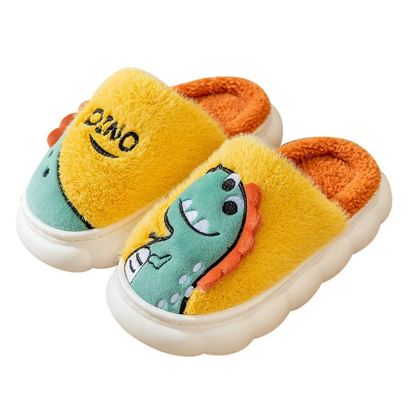 A pair of plush grey dinosaur print slippers with a thickened sole, shown on a wooden floor.