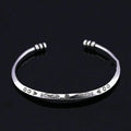Close-up of a silver-toned women's bracelet with a detailed Chinese-style fish charm and an adjustable opening clasp.