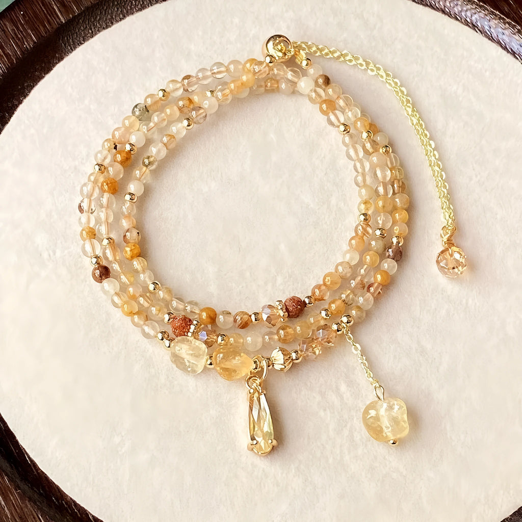 Women's three-circle citrine bracelet with caramel crystals and gold electroplated finish showing Saturn design detail