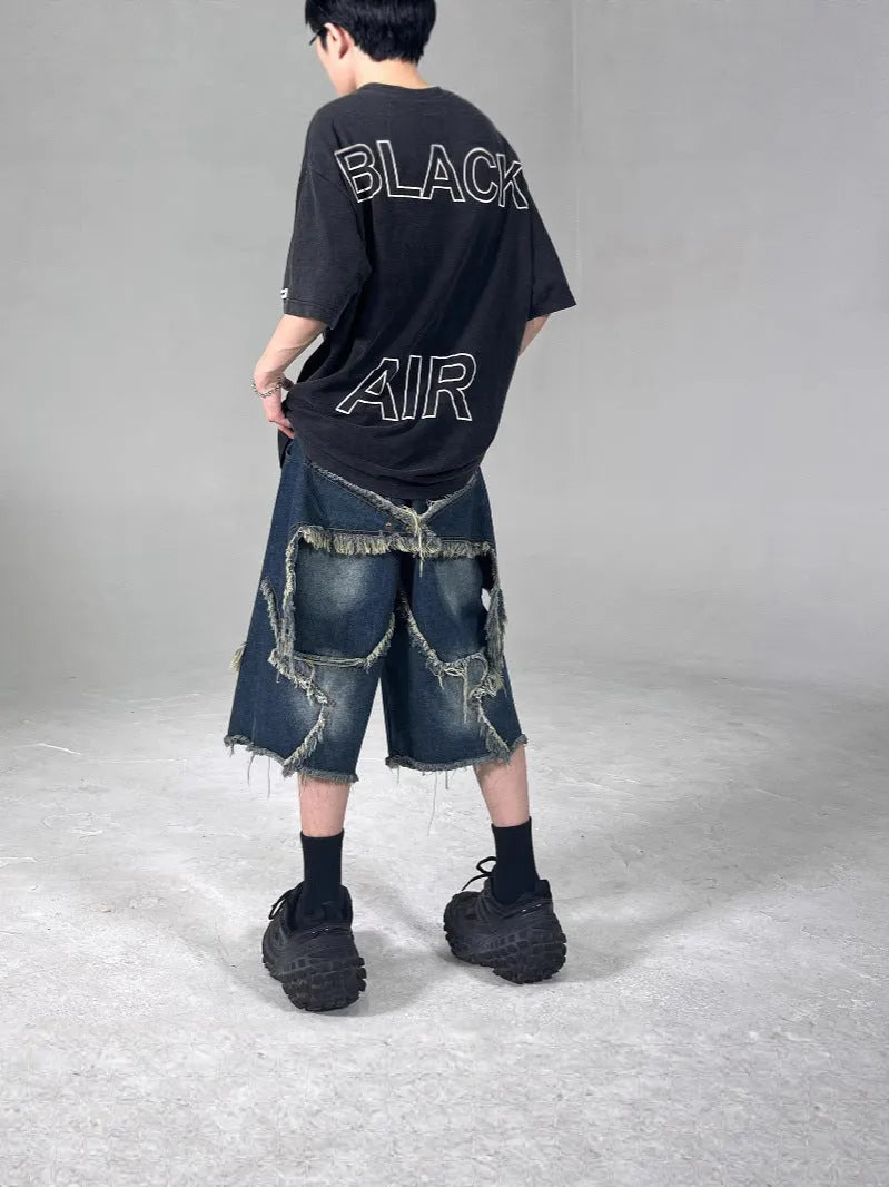 Blue men's loose-fit denim shorts with a frayed five-pointed star design on the leg.