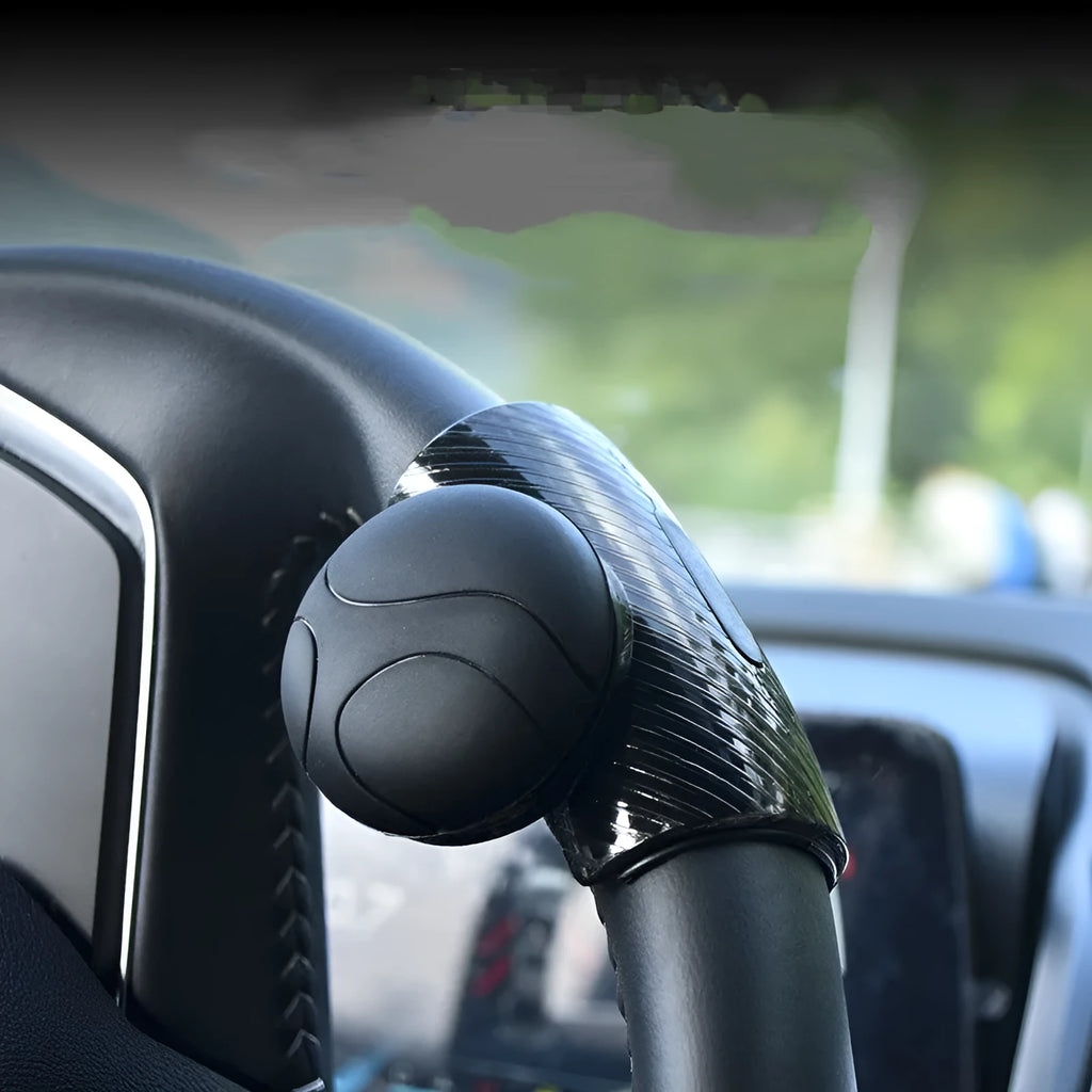 Black silicone steering wheel assistance ball with metal bearing booster installed on car steering wheel