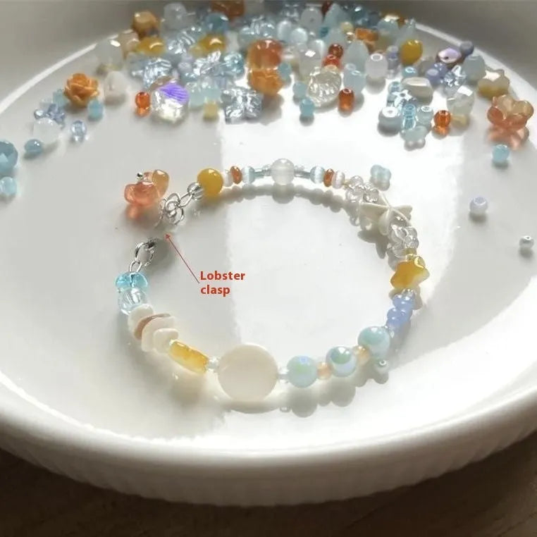 Diamond-shaped mixed-material bracelet for women in orange and sea summer colours with round design elements.