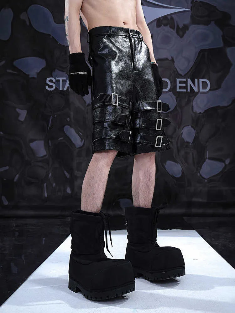 Men's black casual cropped shorts with a prominent leather ring detail on the front.