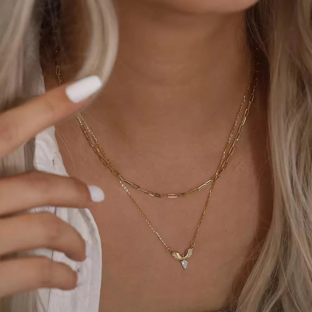 Close-up of an adjustable silver eagle pendant necklace on a textured background, showing the O-ring chain.