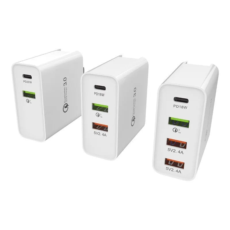 White multi-port fast charge wall charger with international plug options on a desk