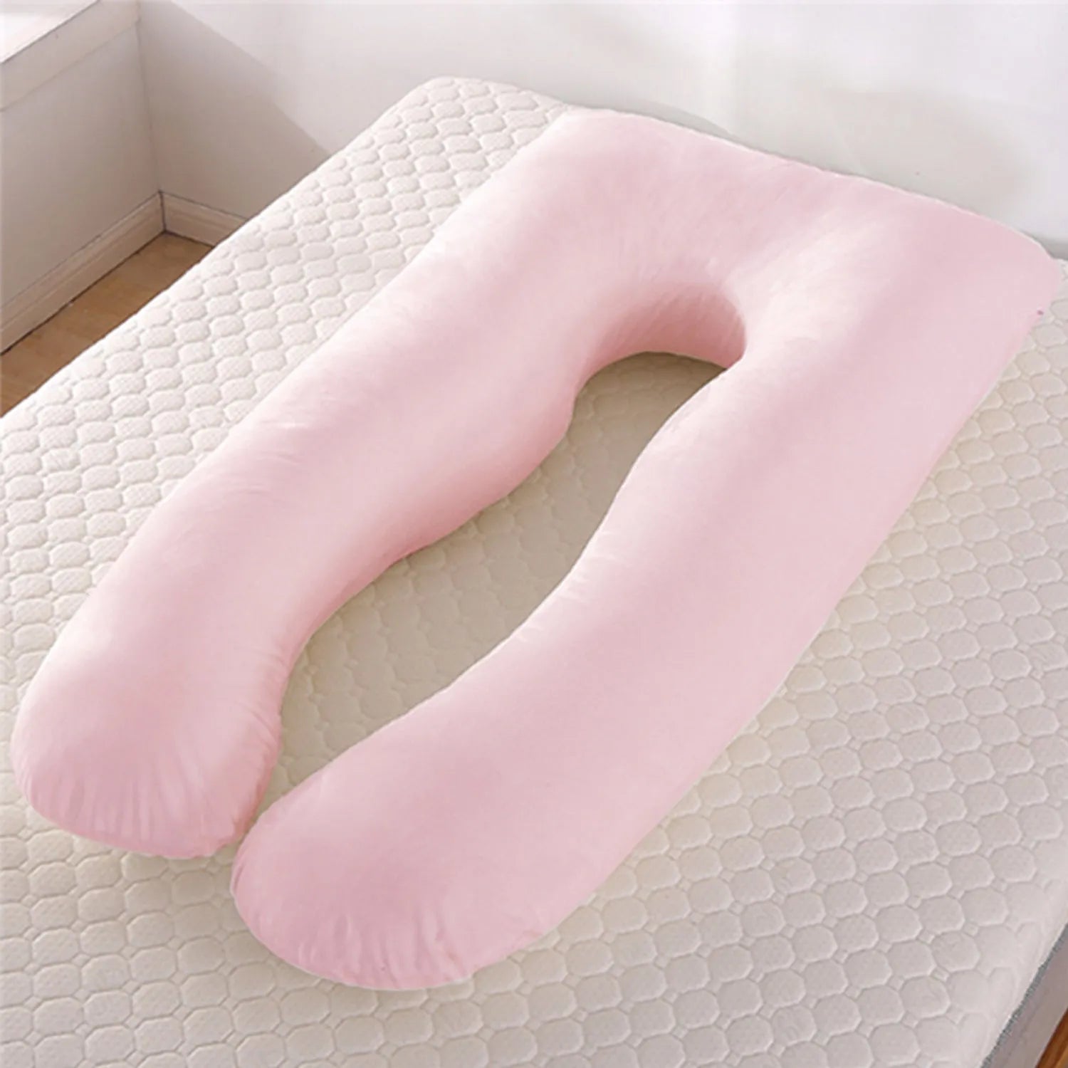 U-shaped white maternity pillow with ice silk cover on a bed, showing its full-body support shape for pregnancy.