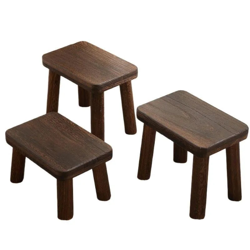 Solid wood distressed finish shoe changing stool on a wooden floor