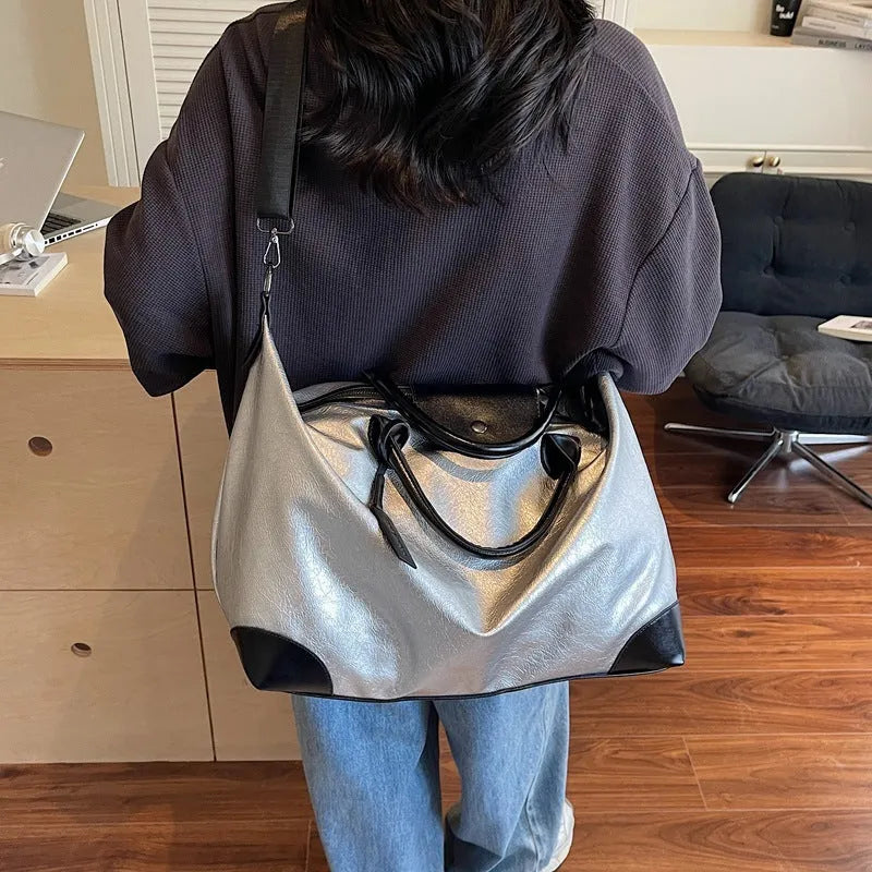 Women's large capacity hand-carry travel bag in black or silver with 36-55 litre capacity