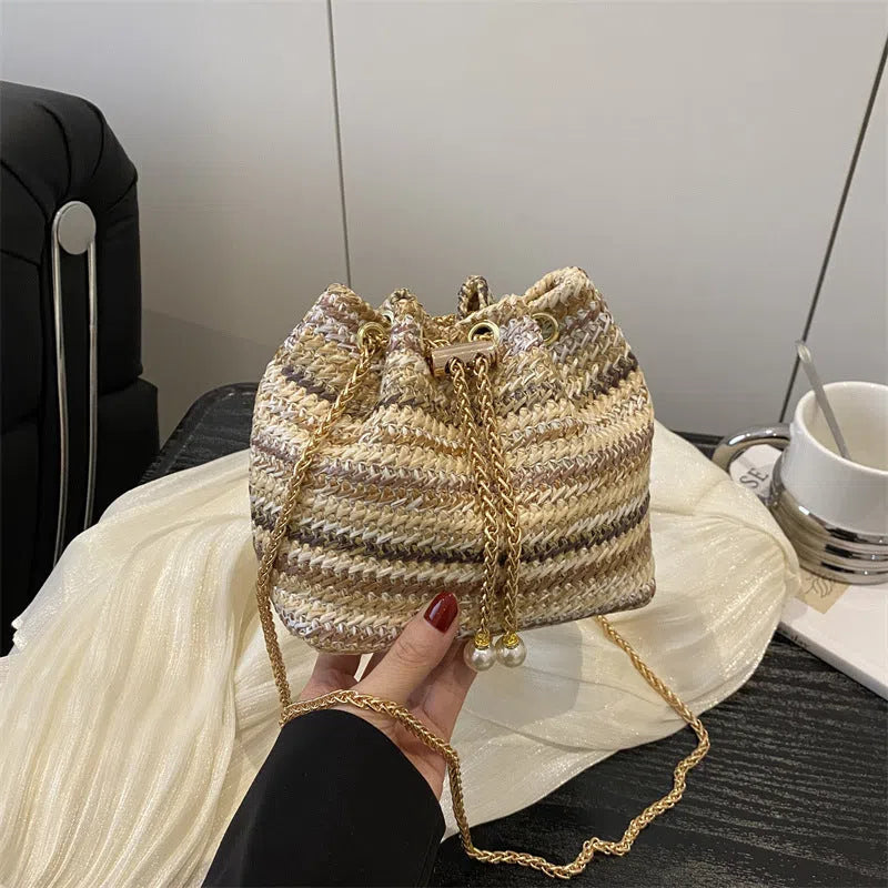 Multicolor straw weave bucket bag with plaid pattern, chain strap, and diamond embellishments