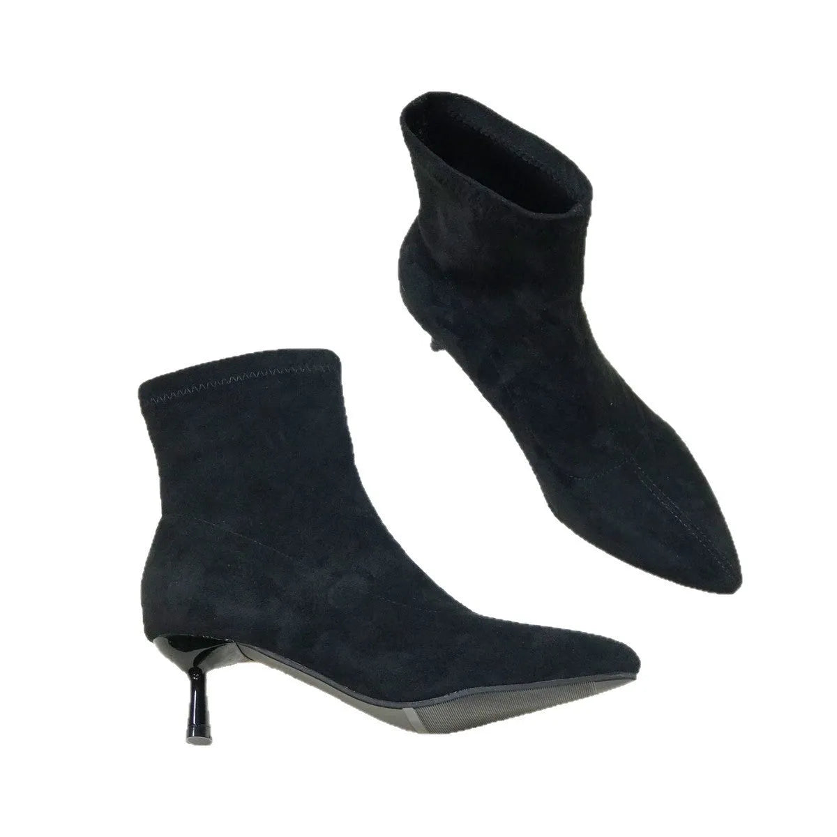 Black microfiber ankle boots with a stiletto heel and pointed toe on a mid-calf sock.