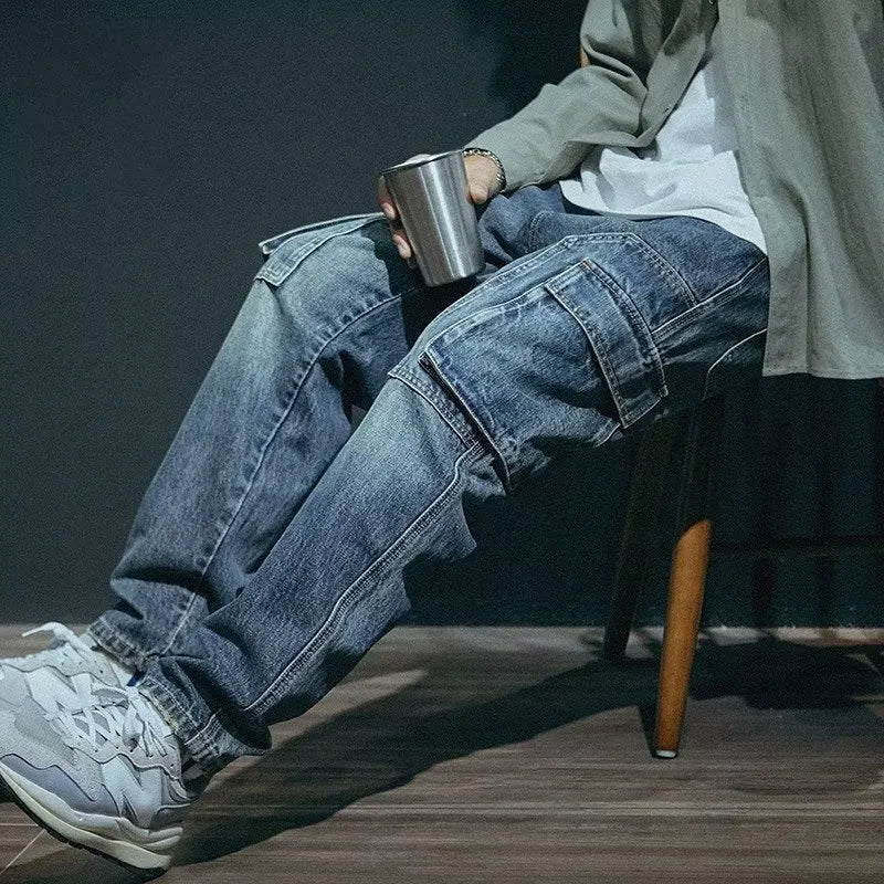 A pair of men's loose straight leg blue jeans on a plain background, showing the zip fly and classic denim style.