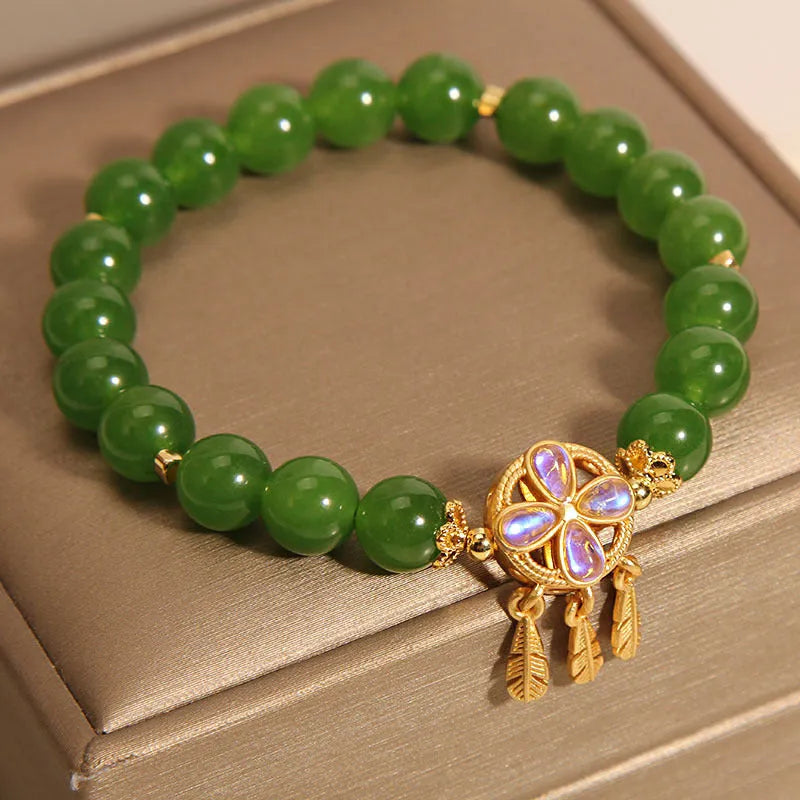 Green jasper crystal four-leaf clover dream catcher pendant bracelet on a natural cotton cord.
