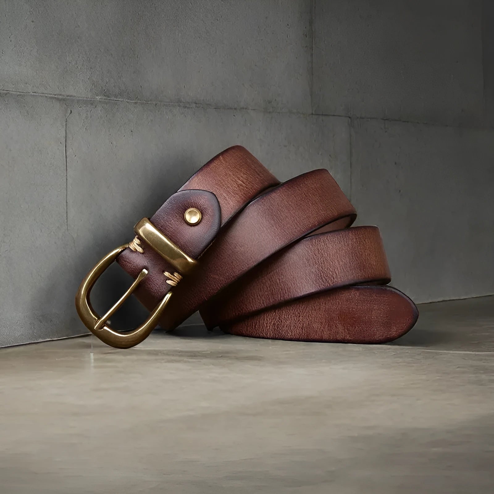 Men's casual leather belt in black with a copper pin buckle on a jeans background
