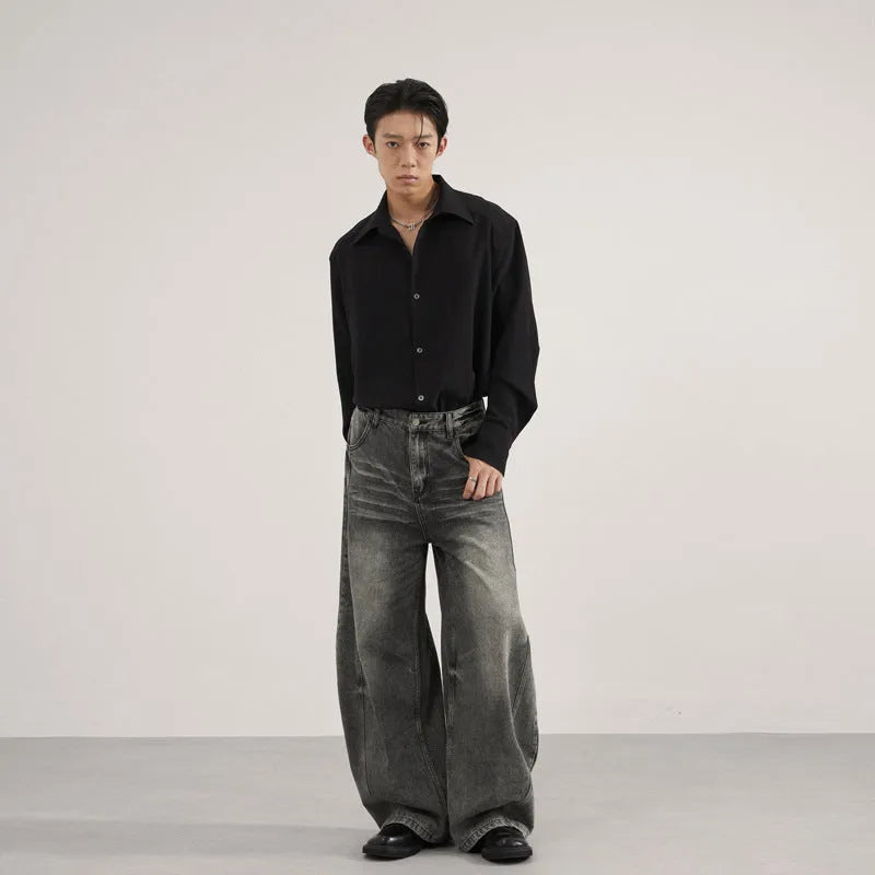 Men's loose straight washed denim jeans in black, front view showing zip fly and straight leg cut.