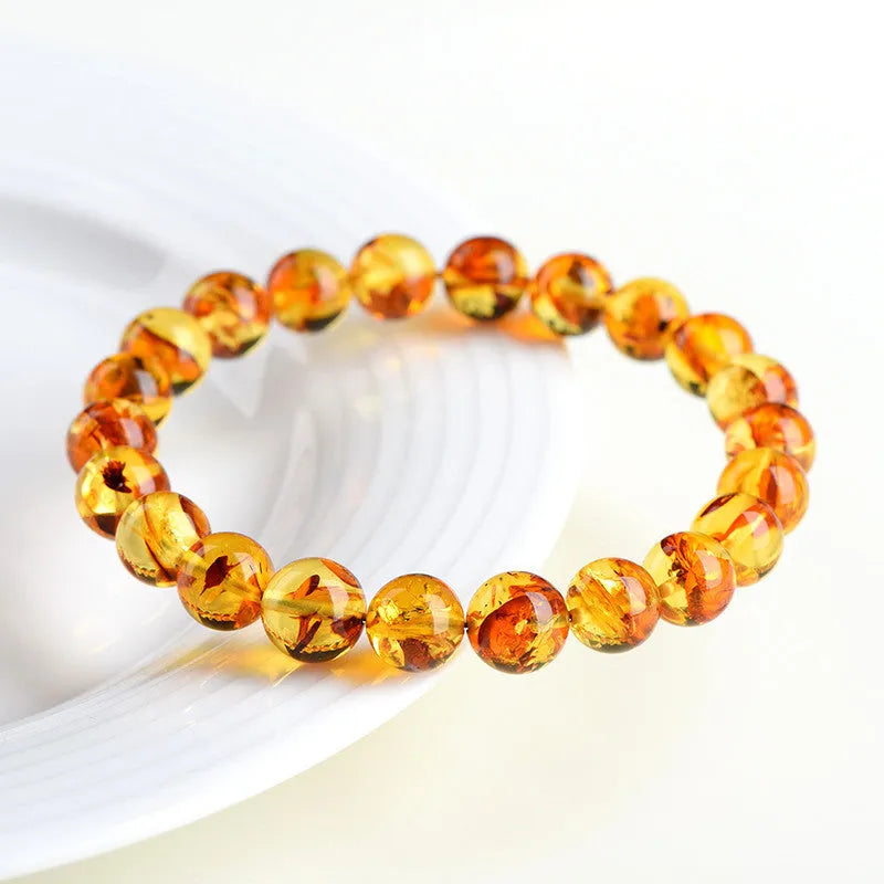 Natural yellow piebald amber bracelet with geometric beads on a wrist.