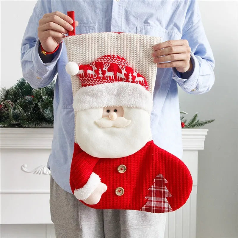 Large red and white knitted Christmas stocking with Santa Claus design hanging from fireplace
