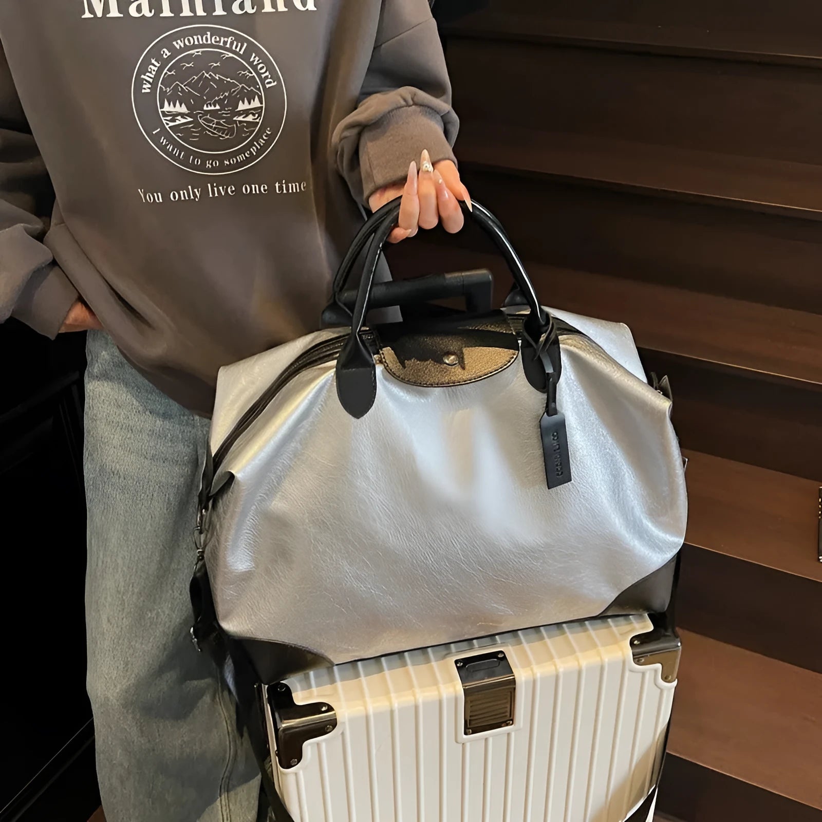 Women's large capacity hand-carry travel bag in black or silver with 36-55 litre capacity