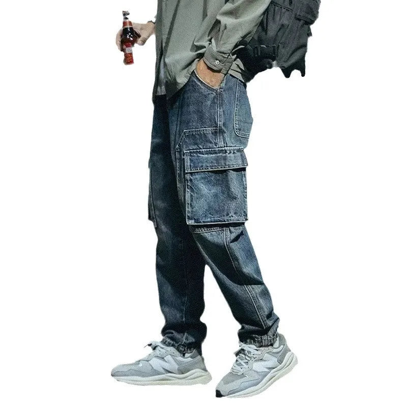 A pair of men's loose straight leg blue jeans on a plain background, showing the zip fly and classic denim style.