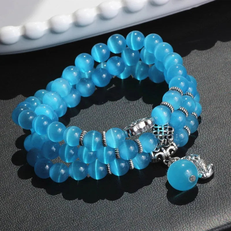 Women's adjustable opal bracelet with Lucky Cat charm and geometric beads in blue.