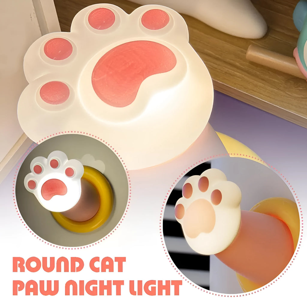 White rechargeable cat paw touch lamp with adhesive back, lit on a bedside table.