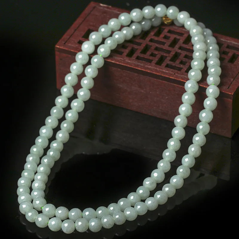 Adjustable length natural jade bead necklace with white and green round beads on a chain.