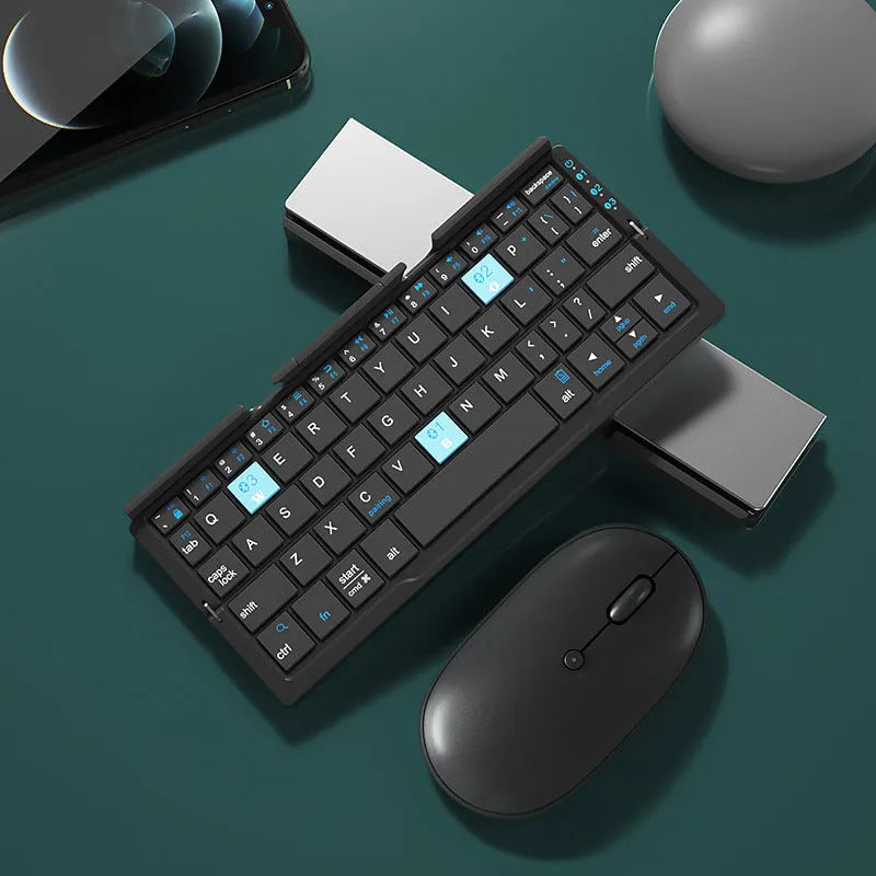 Folded aluminium Bluetooth keyboard showing compact size next to unfolded version with tablet on stand