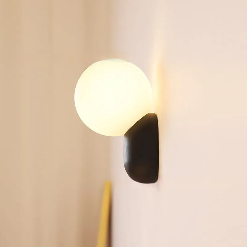 Small night lamp with alloy body and glass shade in matte black, 12×21cm, on a wall
