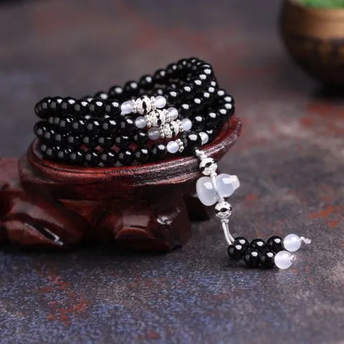 Black agate beaded bracelet with 108 geometric beads and number elements on wrist