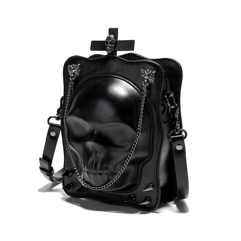 Black square mini crossbody bag with embroidered skull design, metal rivets, and a chain shoulder strap.