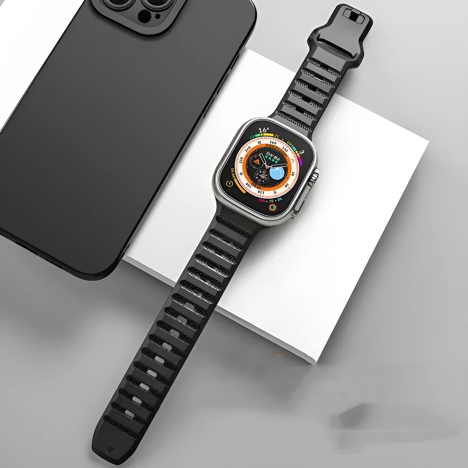 Fluoro rubber Apple Watch strap in multiple colours on a grey background, showing the T-buckle closure.
