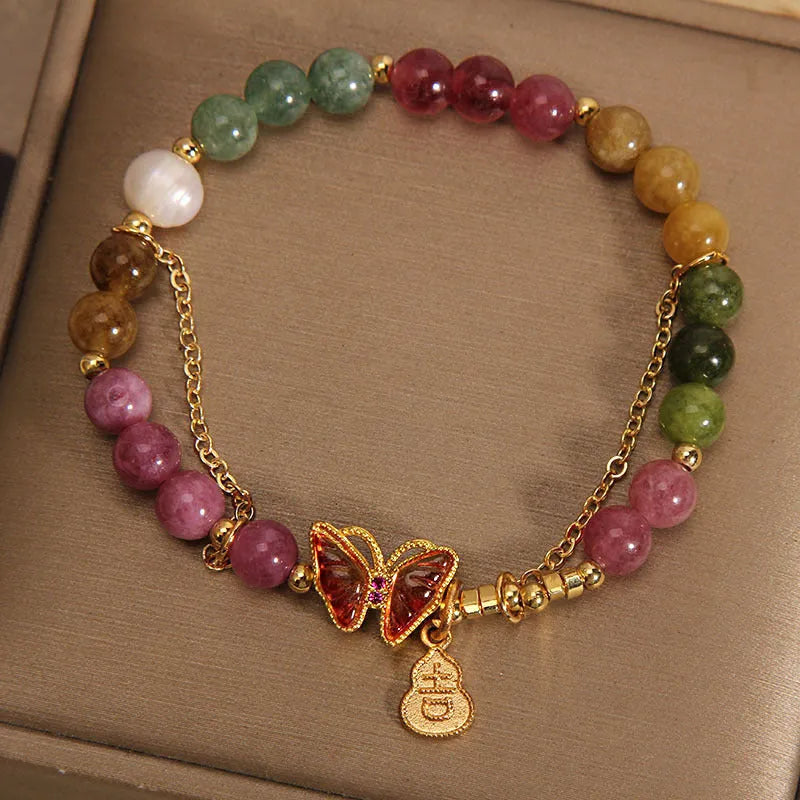 Close-up of a women's agate bracelet with a tourmaline butterfly gourd pendant in natural jade colour.