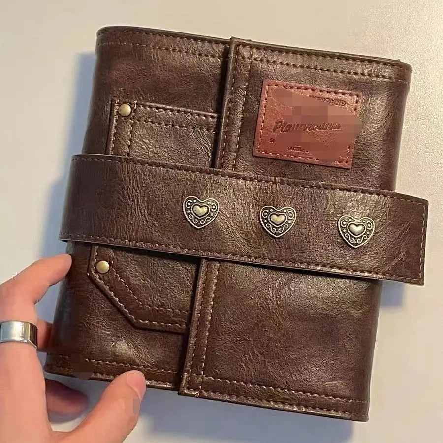 Brown retro-style A7 notebook with a PU cover and leather buckle, shown open to reveal loose-leaf binding.