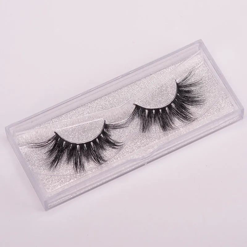 A pair of Affectionate brand 5D false eyelashes made from mink hair, shown with a storage cap and double-headed brush.