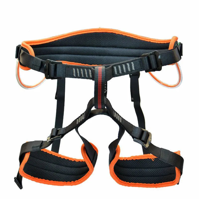 Orange half seat belt climbing safety belt with adjustable waist and leg straps on outdoor rock background