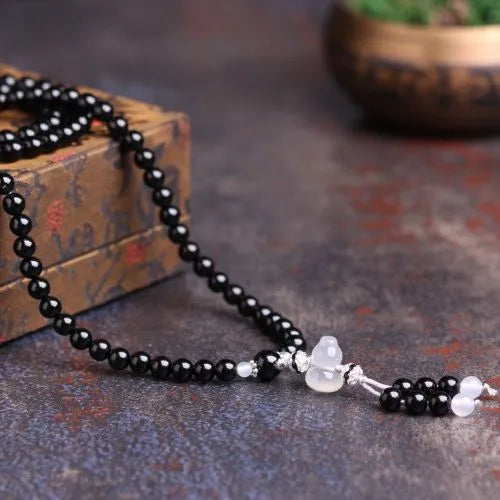 Black agate beaded bracelet with 108 geometric beads and number elements on wrist
