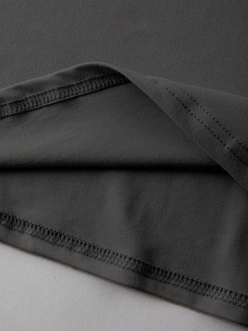 A loose-fitting unisex cotton T-shirt on a hanger, shown in one of its available colours.