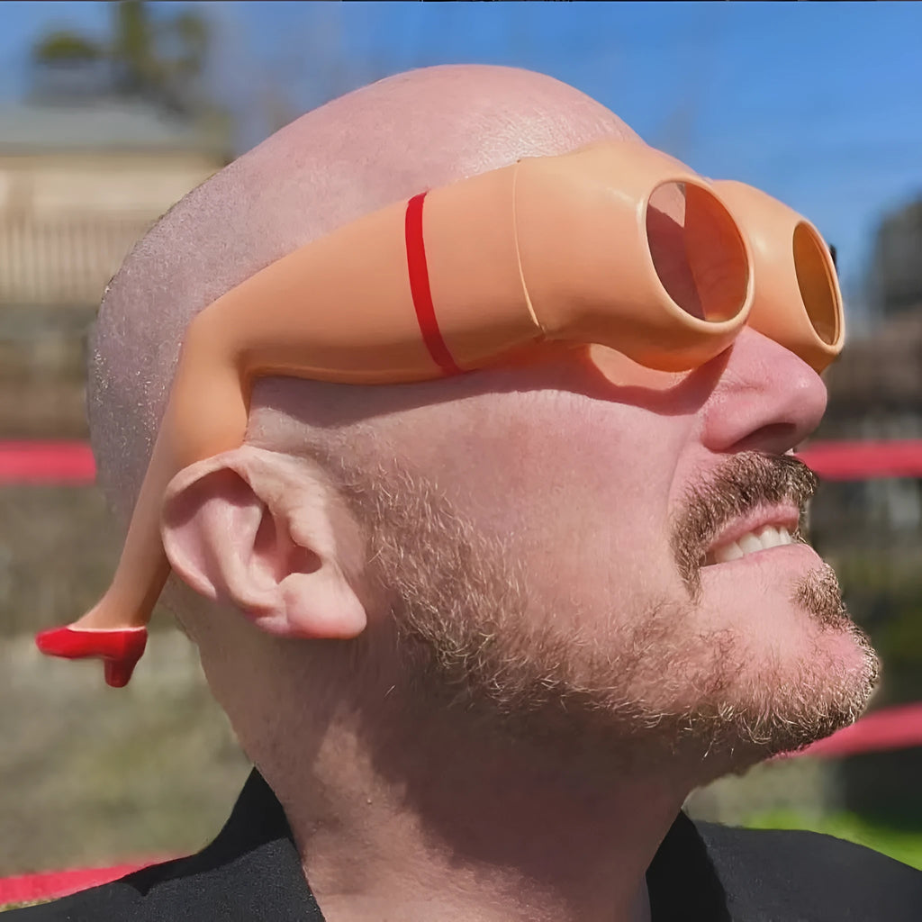 Orange plastic novelty sunglasses accessory for legs and hips on a white background.