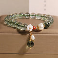 Green phantom quartz crystal bracelet with Bells of Ireland and shell flower design