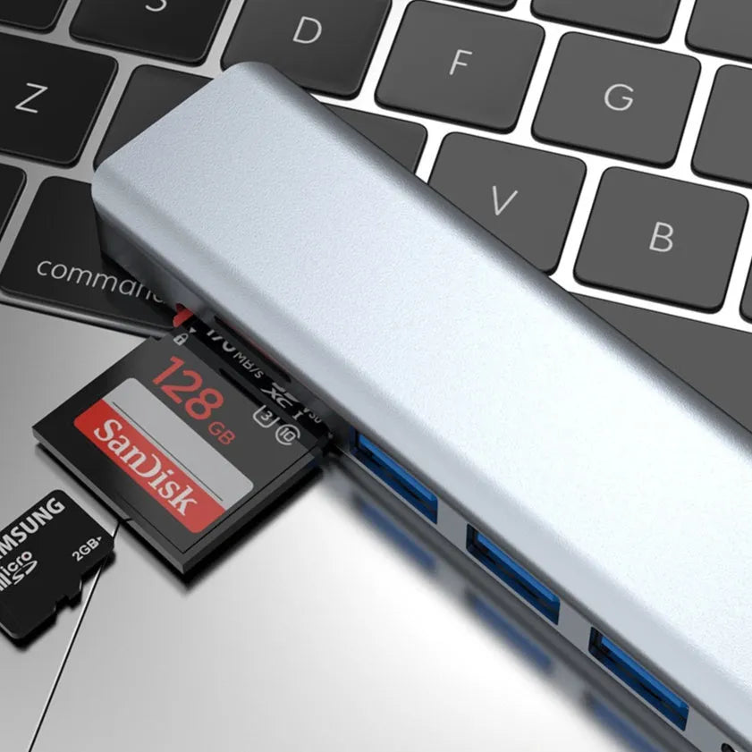 Seven-port USB-C hub expander with short cable shown next to a laptop.
