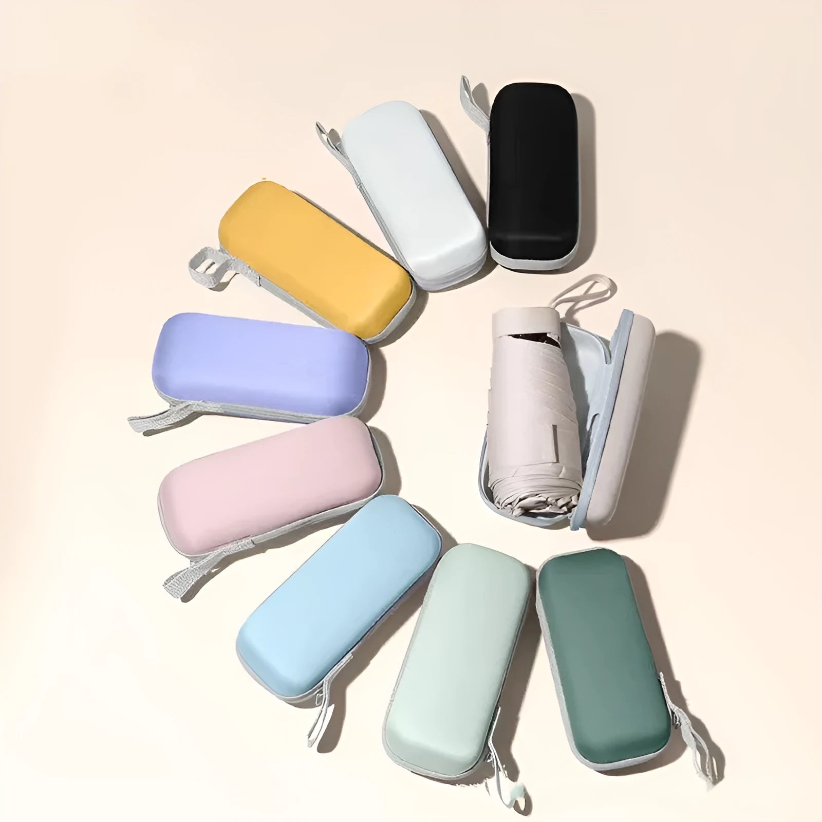 Ultra-light six-fold flat sun umbrella in sky blue with a rubber handle, shown with its capsule storage box.