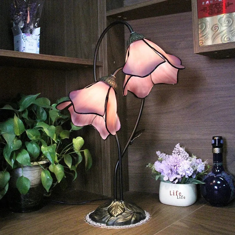 Retro American style table lamp with coloured glass lotus design shade on wooden surface