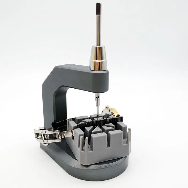 Silver tool steel multi-purpose press strap removal tool on a work surface.