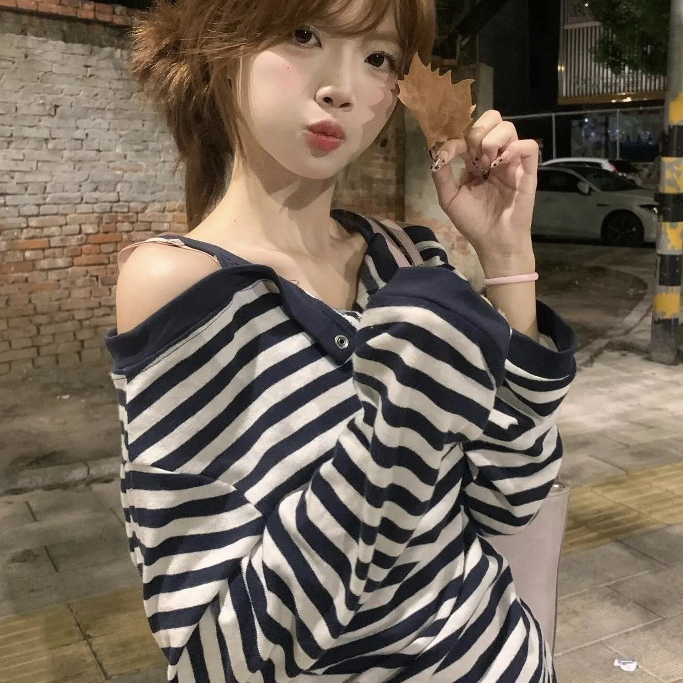 Dark blue Korean-style oversized women's long-sleeved t-shirt with stripes, buttons, and embroidery detail.