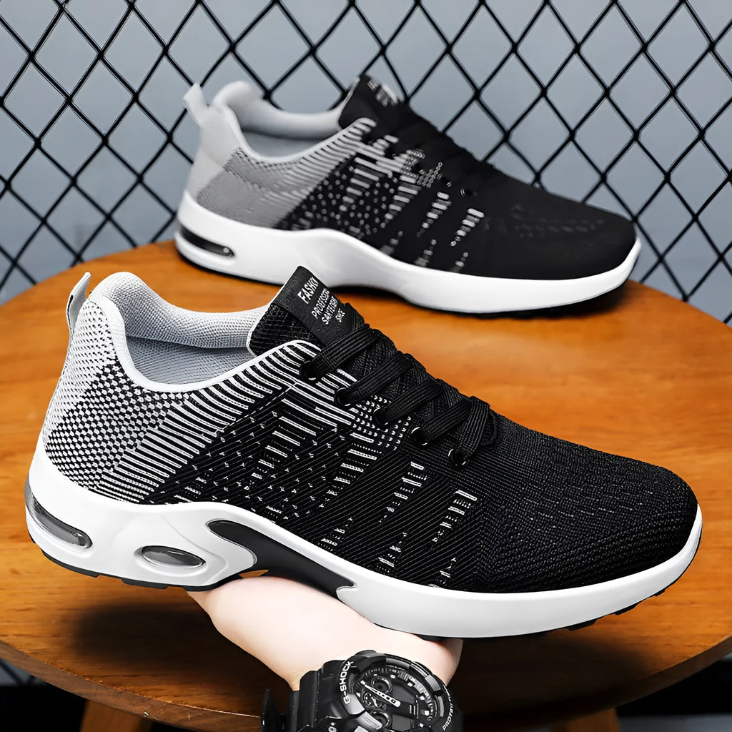 Men's black and grey Flyknit mesh low-top casual sneakers with lace-up front and soft sole.