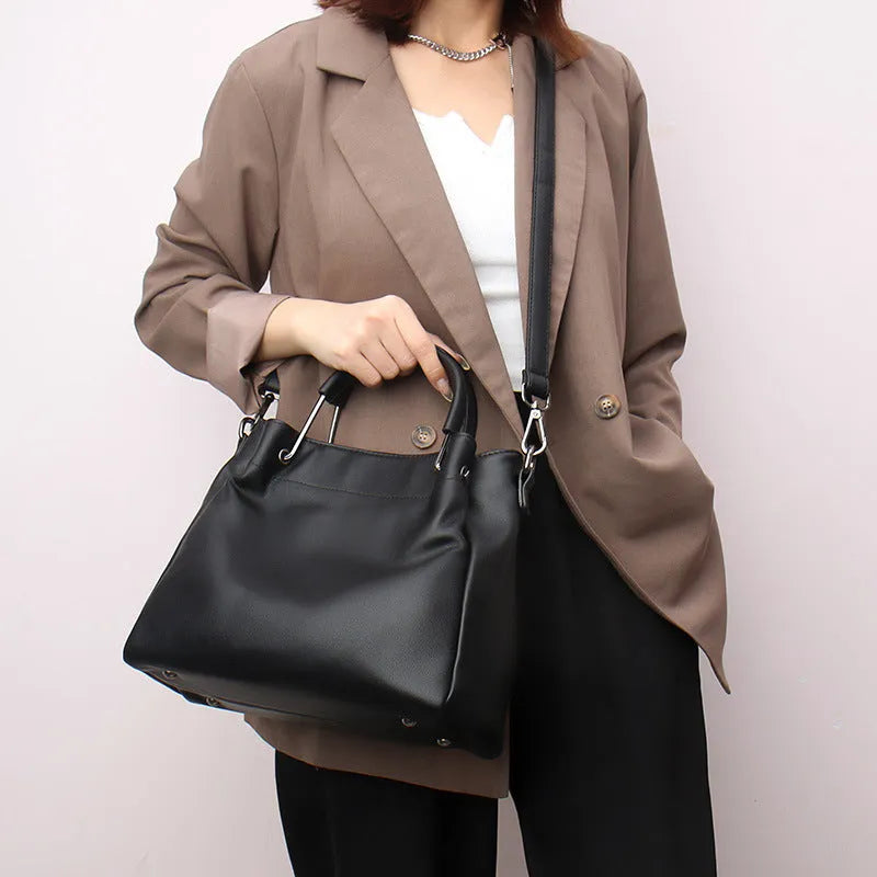 Soft PU leather bucket bag in black with visible sewing thread and external slit pocket