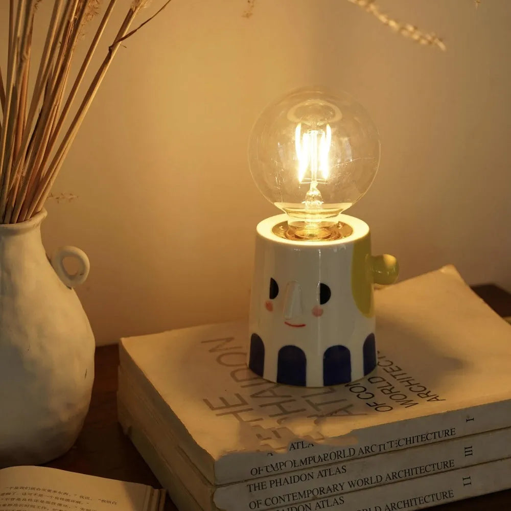 Handmade ceramic table lamp with a spherical white ball headlight shade on a solid base.