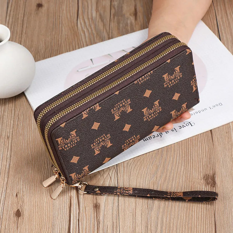 Black retro print long wallet clutch bag with zipper, holding a mobile phone and cards.